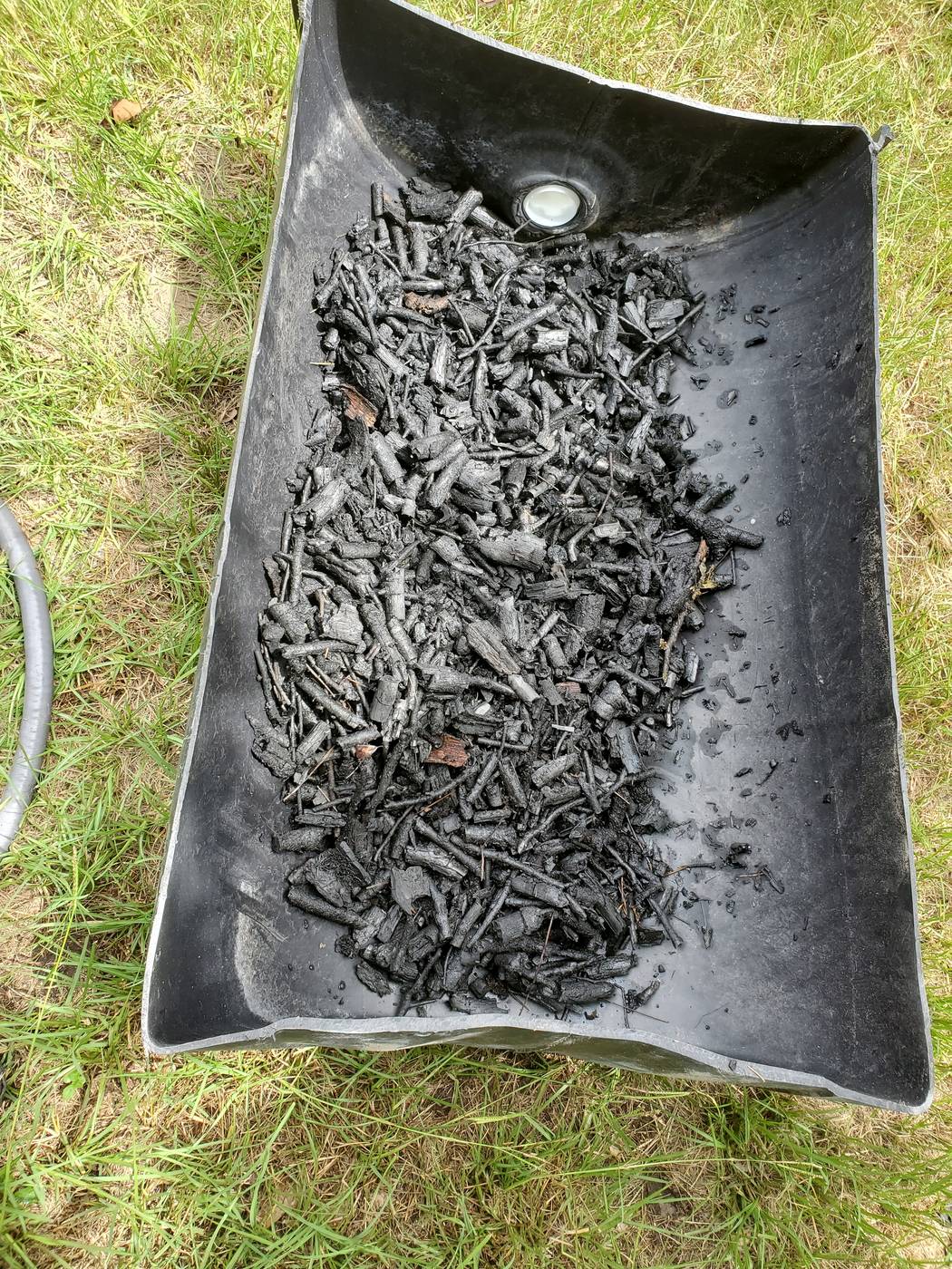 Biochar stored in a half barrel after processing